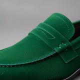 Mocassim Penny Loafer Milano Cognac: detalhe da textura verde, da faixa frontal e da costura.