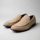 Mocassim Penny Loafer Milano Cognac: par bege em vista diagonal, com faixa frontal e sola preta.