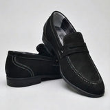 Mocassim Penny Loafer Milano Cognac: par preto em posição cruzada, com faixa frontal e costura clara.