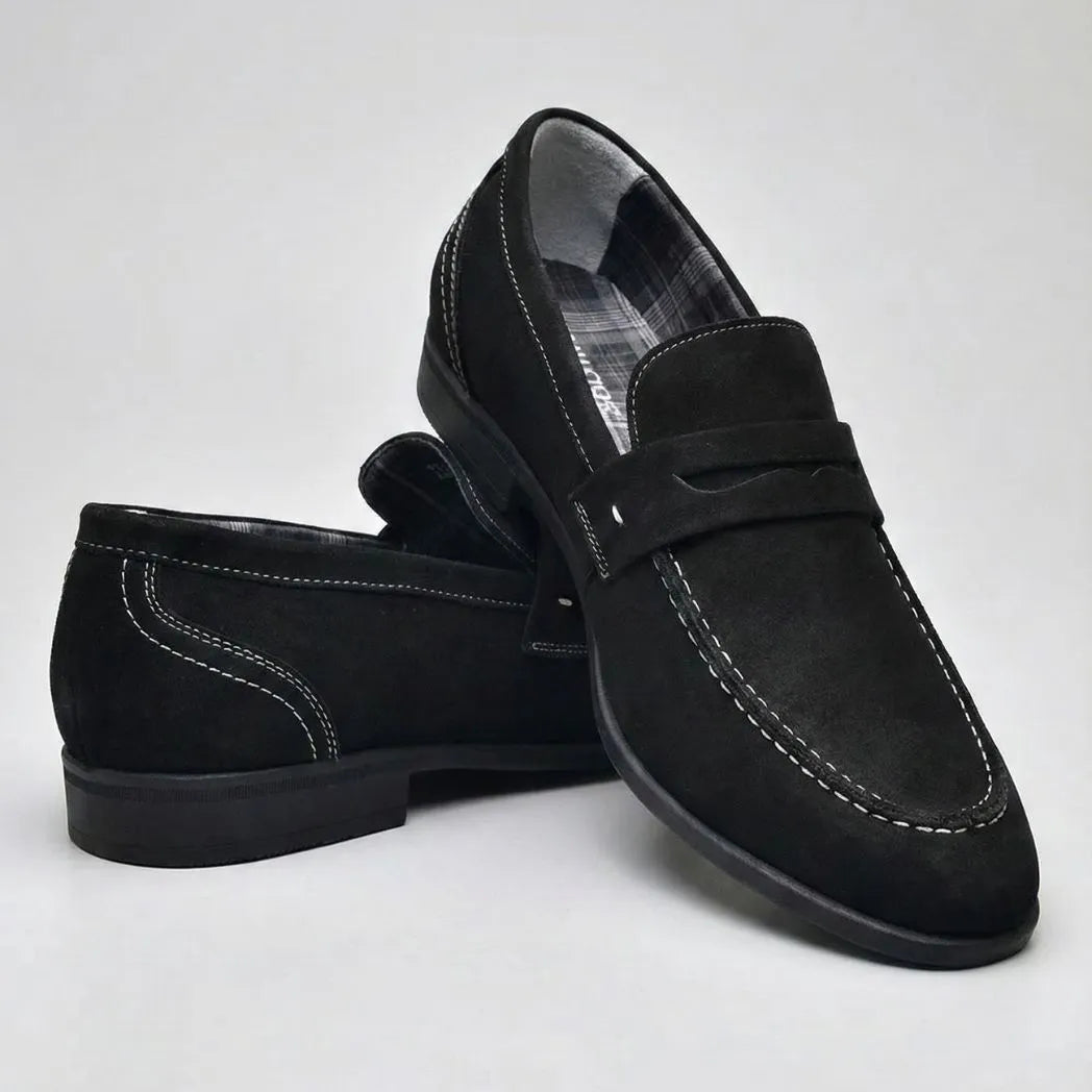 Mocassim Penny Loafer Milano Cognac: par preto em posição cruzada, com faixa frontal e costura clara.