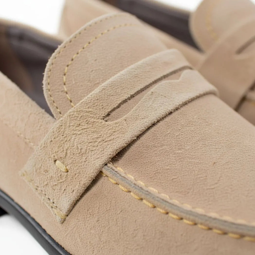 Mocassim Penny Loafer Milano Cognac: detalhe da textura bege, da faixa frontal e da costura clara.