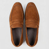 Mocassim Penny Loafer Milano Cognac: par marrom visto de cima, mostrando faixa frontal e interior escuro.