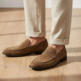 Mocassim Penny Loafer Milano Cognac: par marrom-claro usado com calça clara dobrada na barra.