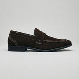 Mocassim Penny Loafer Milano Cognac: modelo marrom-escuro de perfil, com faixa frontal e sola preta.