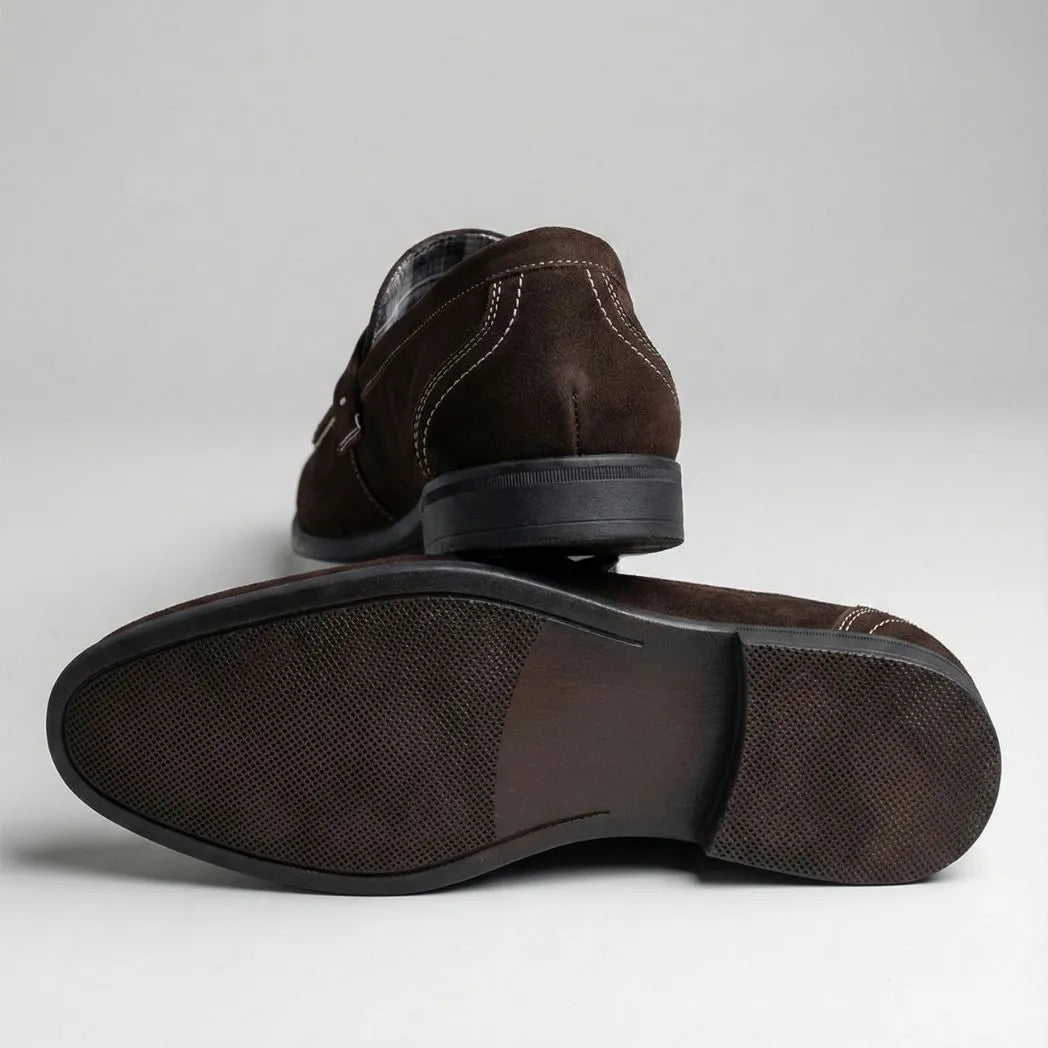 Mocassim Penny Loafer Milano Cognac: par marrom-escuro com um sapato virado, mostrando a sola escura.