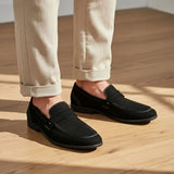 Mocassim Penny Loafer Milano Cognac: par preto usado com calça clara dobrada na barra.