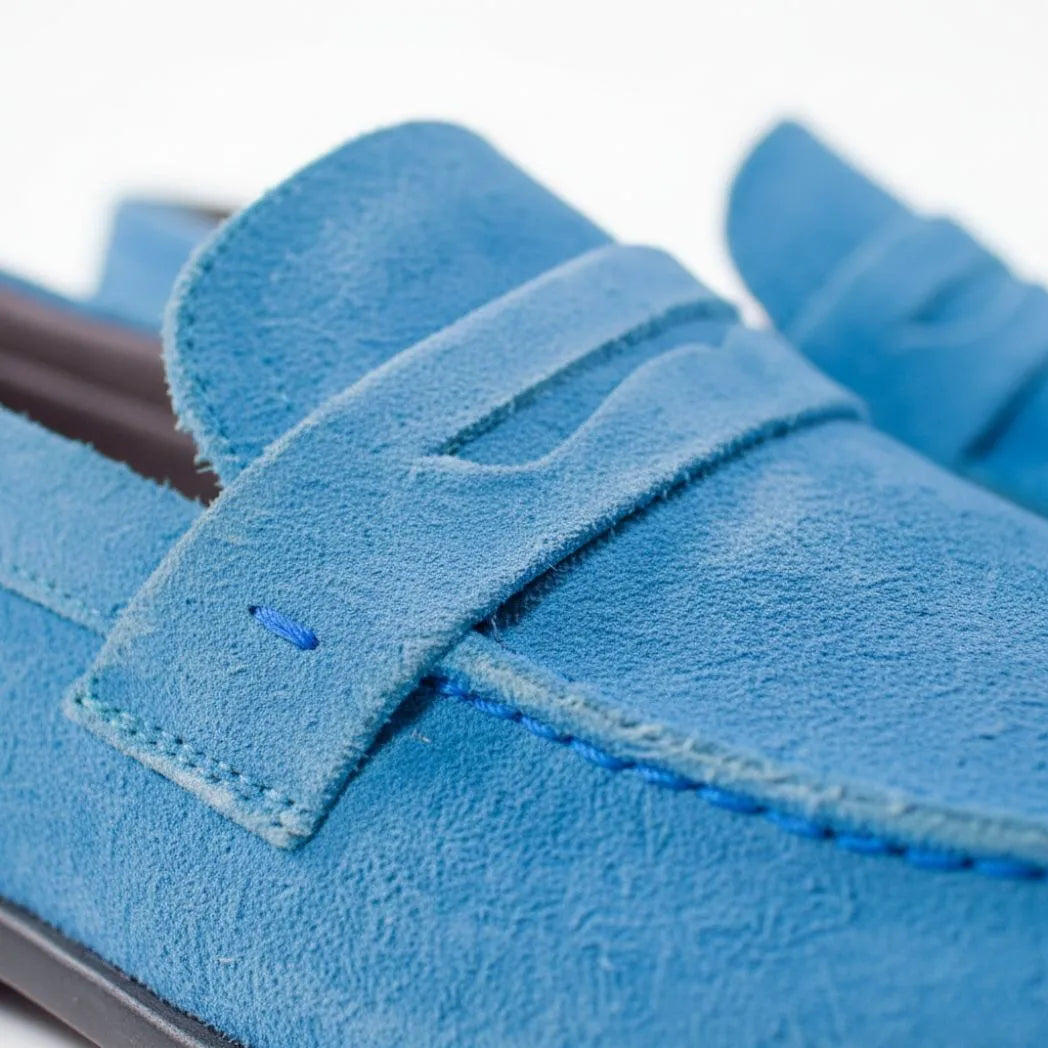 Mocassim Penny Loafer Milano Cognac: detalhe da textura azul, da faixa frontal e da costura.