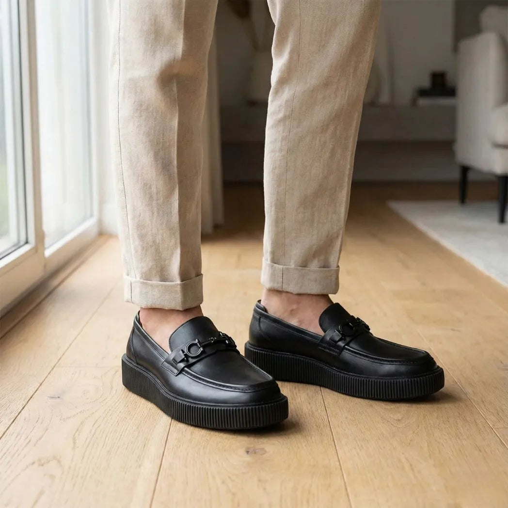 Mocassim Plataform com Fivela na cor preto, usado com calça clara de barra dobrada.