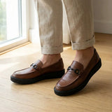Mocassim Plataform com Fivela na cor marrom, usado com calça clara de barra dobrada.
