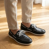 Mocassim Sider de Couro: par preto com cadarços brancos usado com calça clara dobrada na barra.