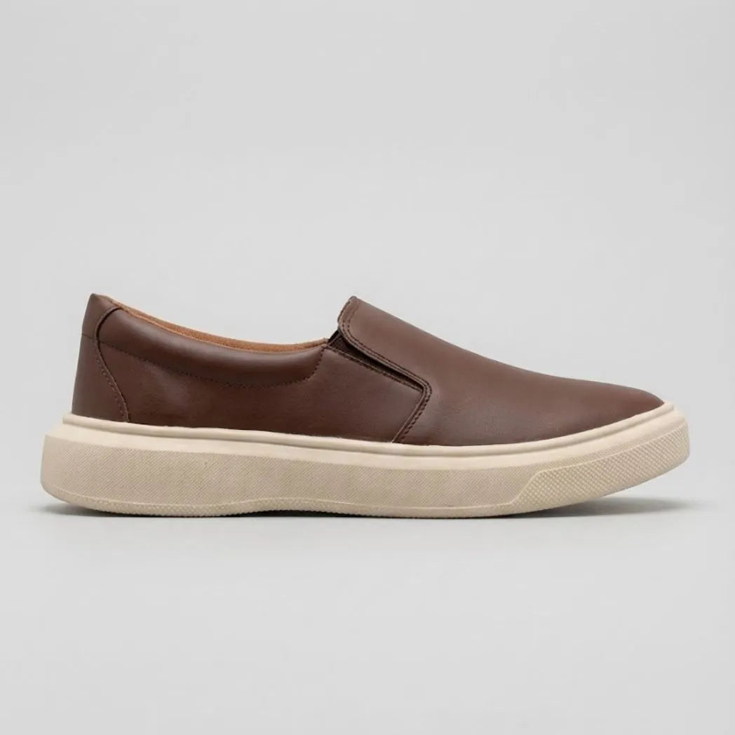 Mocassim Slip On Casual de Couro: modelo marrom de perfil, com costura lateral e sola bege.