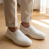 Mocassim Slip On Casual de Couro: par branco usado com calça bege dobrada na barra.