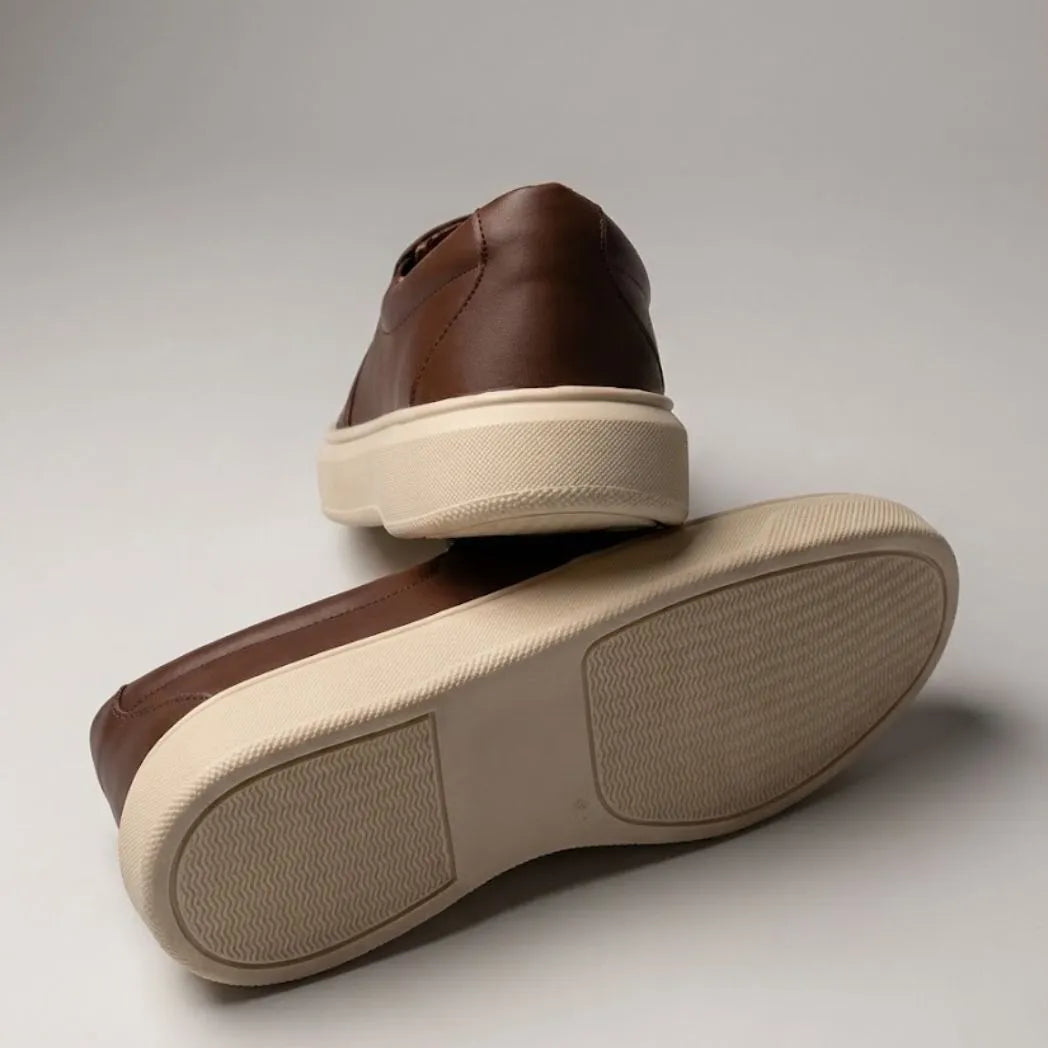 Mocassim Slip On Casual de Couro: par marrom com um sapato virado, mostrando a sola bege.