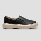 Mocassim Slip On Casual de Couro: modelo preto de perfil, com sola bege.