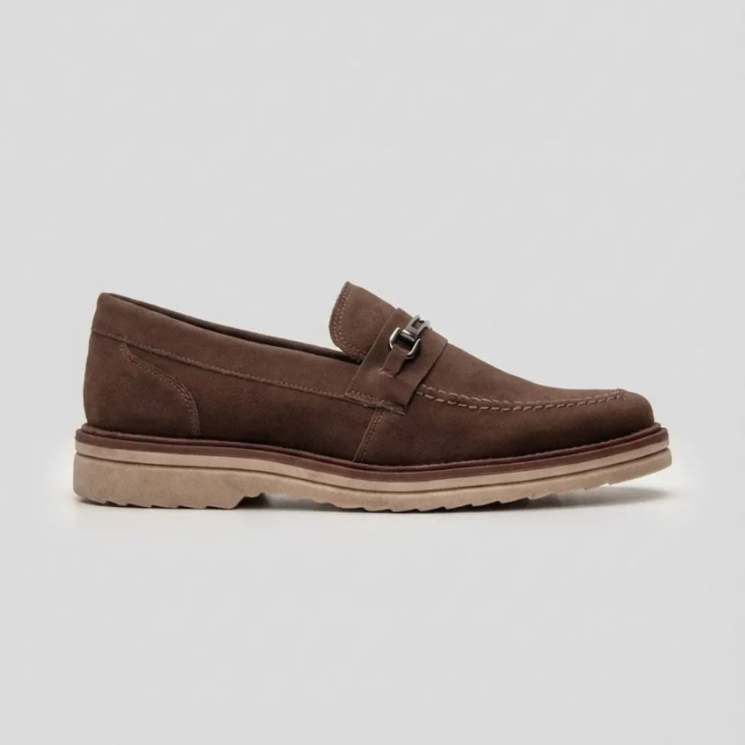 Mocassim Suede Tratorado de Camurça: modelo marrom de perfil, com pequena ferragem frontal e sola bege com sulcos.