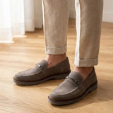 Mocassim Suede Tratorado de Camurça na cor cinza, usado com calça clara de barra dobrada.