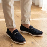 Mocassim Suede Tratorado de Camurça na cor azul-escuro, usado com calça clara de barra dobrada.