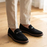 Mocassim Suede Tratorado de Camurça na cor preto, usado com calça clara de barra dobrada.
