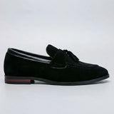 Mocassim Tassel de Camurça Premium: modelo preto de perfil, com enfeite de franjas e detalhe vermelho na sola.