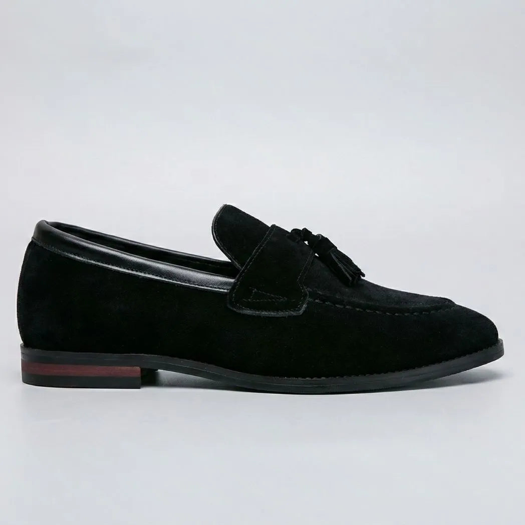 Mocassim Tassel de Camurça Premium: modelo preto de perfil, com enfeite de franjas e detalhe vermelho na sola.