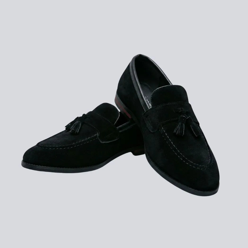 Mocassim Tassel de Camurça Premium: par preto em posição cruzada, com enfeites de franjas na parte frontal.