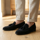 Mocassim Tassel de Camurça Premium: par preto com enfeites de franjas usado com calça clara dobrada na barra.