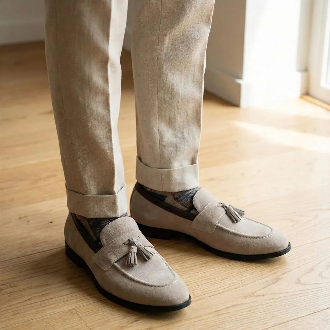 Mocassim Tassel de Camurça Premium: par bege com enfeites de franjas usado com calça clara dobrada na barra.