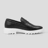 Mocassim Torino Ripple Tratorado de Couro: modelo preto de perfil, com faixa frontal e sola branca com sulcos profundos.