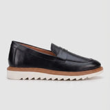 Mocassim Tratorado Milano de Couro: modelo preto de perfil, com faixa frontal, borda marrom e sola branca com sulcos profundos.