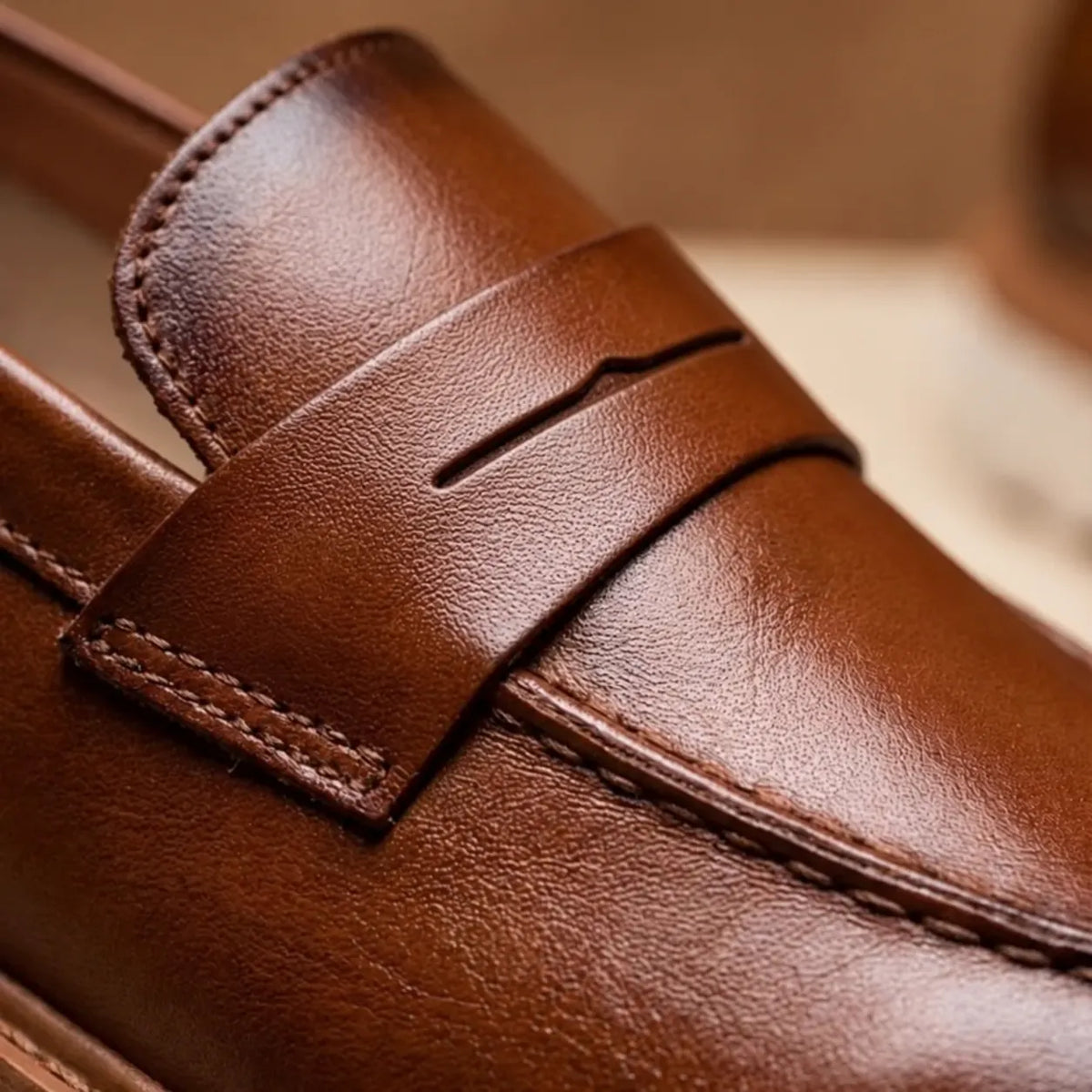 Detalhe do couro marrom e da faixa penny lisa do Mocassim Tratorado Milano.