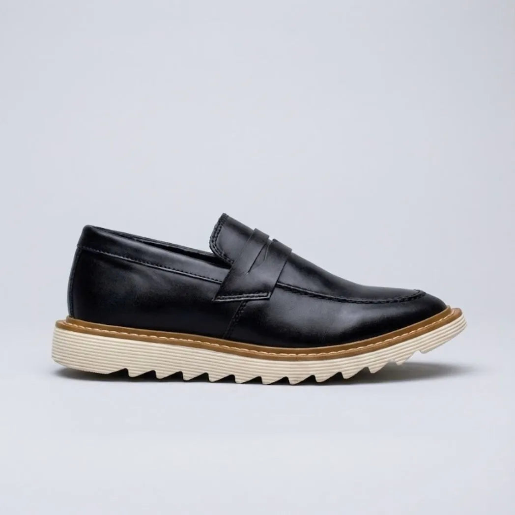 Mocassim Tratorado Siena Ripple: modelo preto de perfil, com faixa frontal, borda marrom e sola bege com sulcos em zigue-zague.