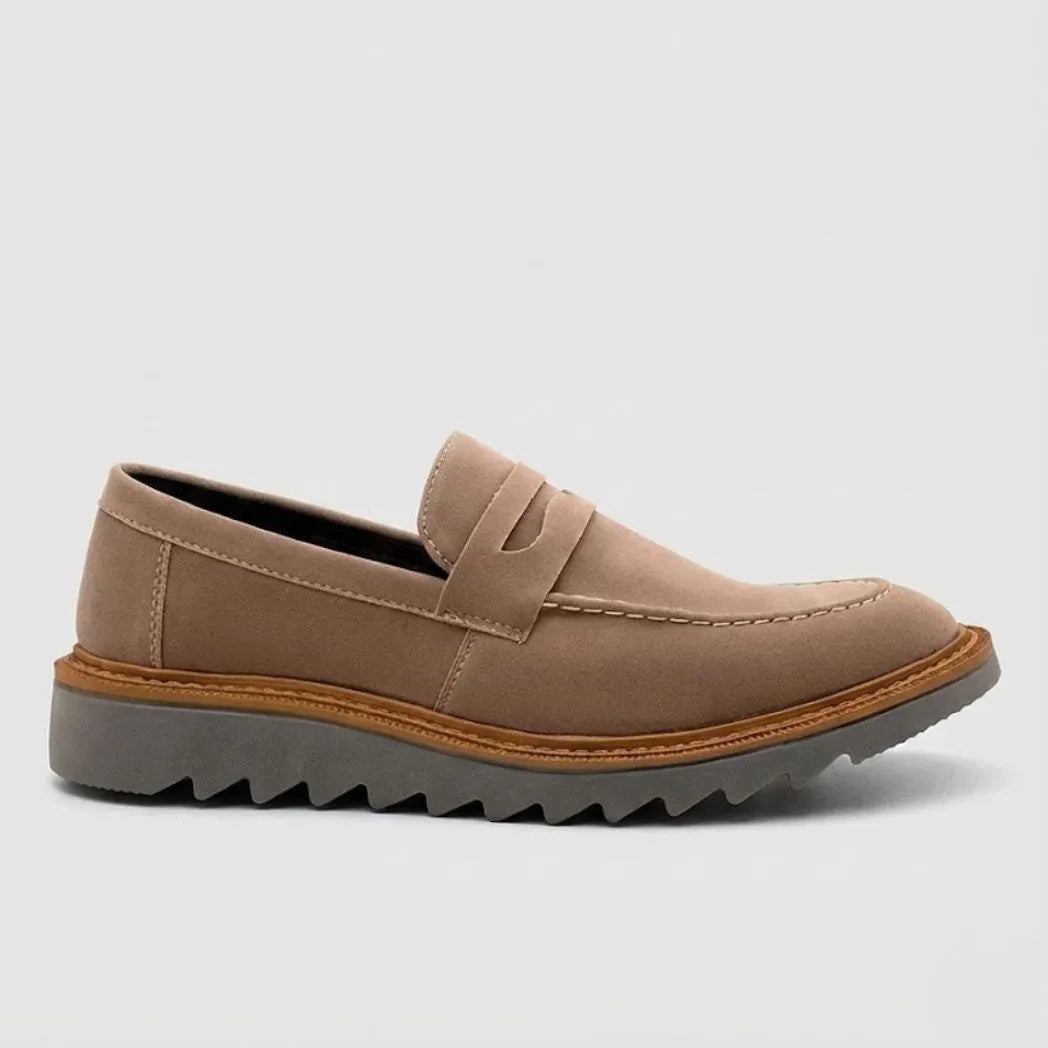 Mocassim Tratorado Taupe de Camurça: modelo bege de perfil, com faixa frontal, borda marrom e sola cinza com sulcos profundos.
