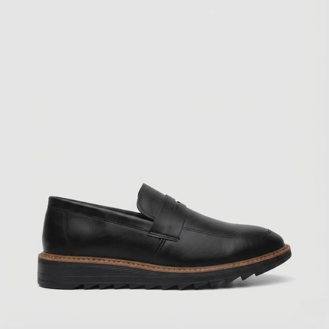 Mocassim Tratorado Torino Ripple: modelo preto de perfil, com faixa frontal, borda marrom e sola preta com sulcos.