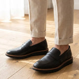 Mocassim Tratorado Torino Ripple na cor preto, usado com calça clara de barra dobrada.