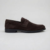 Mocassim Turim Loafer Camurça Marrom: modelo marrom-escuro de perfil, com faixa frontal e sola preta.