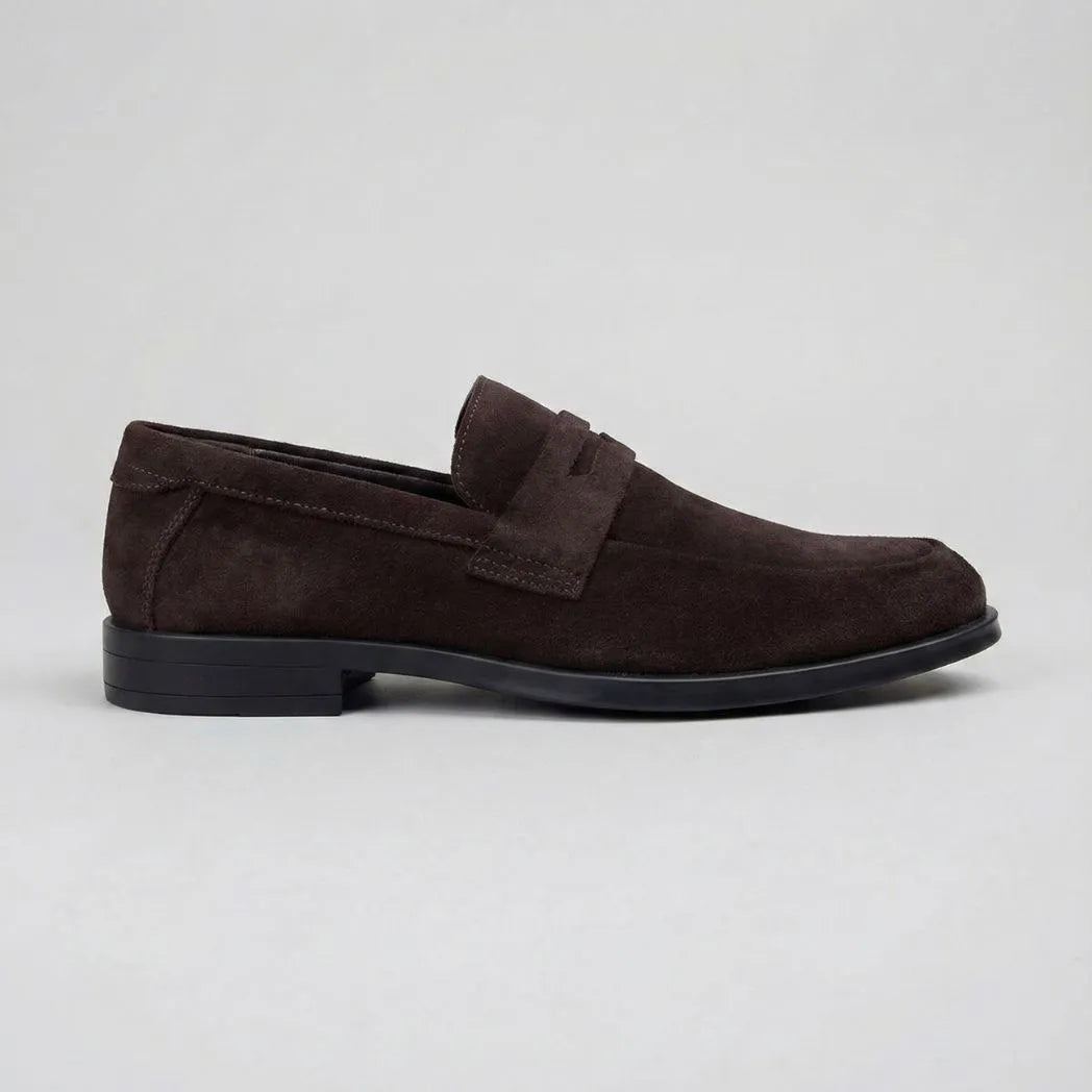 Mocassim Turim Loafer Camurça Marrom: modelo marrom-escuro de perfil, com faixa frontal e sola preta.
