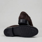 Mocassim Turim Loafer Camurça Marrom: par marrom-escuro com um sapato virado, mostrando a sola preta.