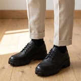 Mocassim Vanguard Tratorado na cor preto, usado com calça clara de barra dobrada.