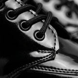 Detalhe do acabamento brilhante, das costuras e dos cadarços do Mocassim Vanguard Tratorado preto.