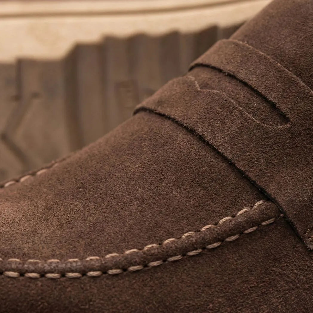 Mocassim de Camurça Monaco Edition: detalhe da textura marrom, da faixa frontal e da costura clara.