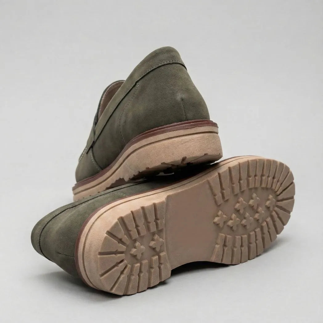 Mocassim de Camurça Monaco Edition: par verde-oliva com um sapato virado, mostrando a sola bege com sulcos.