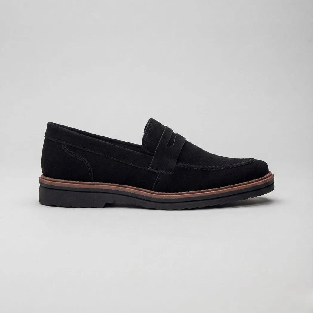 Mocassim de Camurça Monaco Edition: modelo preto de perfil, com faixa frontal e borda marrom na sola.