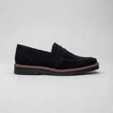 Mocassim de Camurça Monaco Edition: modelo preto de perfil, com faixa frontal e borda marrom na sola.
