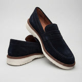 Mocassim de Camurça Monaco Edition: par azul-escuro em posição cruzada, com faixa frontal e sola clara.