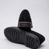 Mocassim de Camurça Monaco Edition: par preto com um sapato virado, mostrando a sola escura com sulcos.