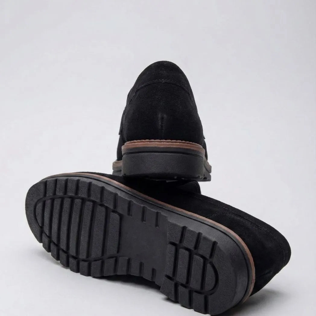 Mocassim de Camurça Monaco Edition: par preto com um sapato virado, mostrando a sola escura com sulcos.