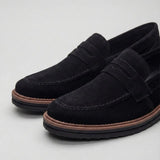 Mocassim de Camurça Monaco Edition: par preto em vista diagonal, com faixa frontal e borda marrom na sola.