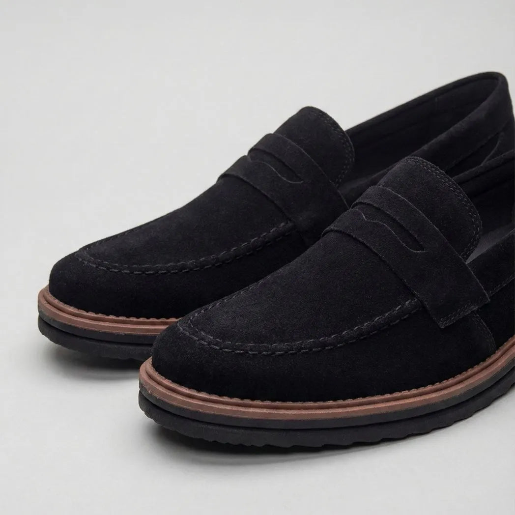 Mocassim de Camurça Monaco Edition: par preto em vista diagonal, com faixa frontal e borda marrom na sola.