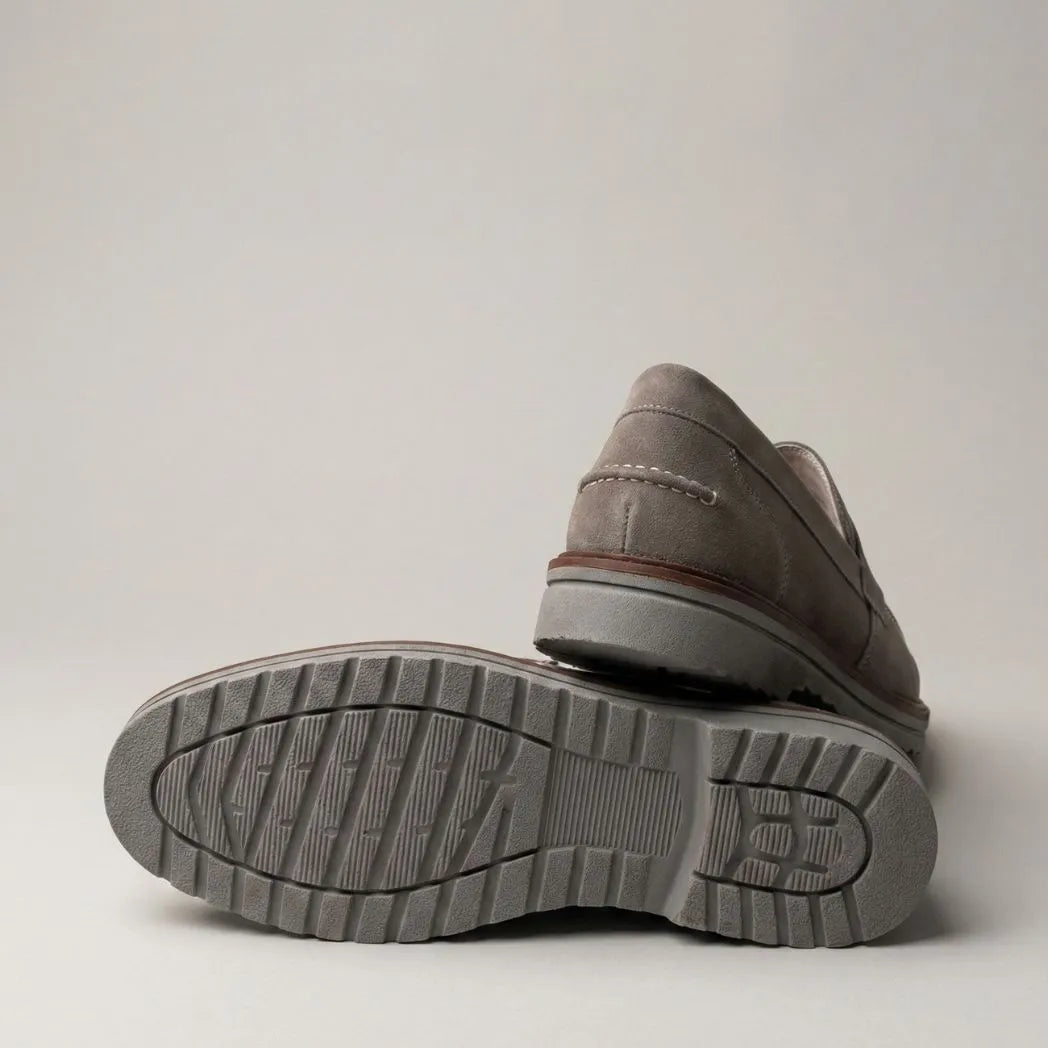 Mocassim de Camurça Monaco Edition: par cinza com um sapato virado, mostrando a sola escura com sulcos.