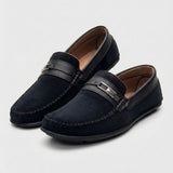 Mocassim de Camurça Titan Coffee: par preto em vista diagonal, com ferragem retangular na faixa frontal.